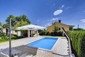 une piscine avec un parasol et des chaises ainsi qu'une maison dans l'établissement Villa Semy, à Lindar