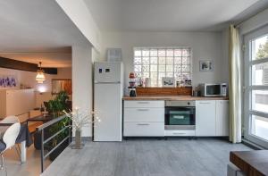 a kitchen with a white refrigerator and a table at House Zoya in Ližnjan