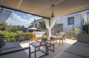 a patio with chairs and tables under a canopy at House Zoya in Ližnjan