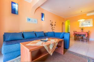 a living room with a blue couch and a table at Apartment Eliana in Banjole