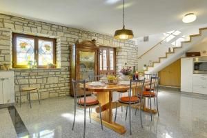 a kitchen and dining room with a table and chairs at Villa Orbanici in Orbanići