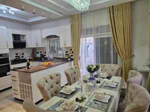 a dining room with a table and chairs and a kitchen at Serene villaz in Kampala