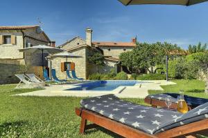 a backyard with a swimming pool and a house at Villa Orbanici in Orbanići