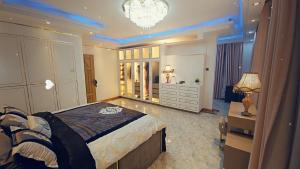 a bedroom with a bed and a desk and a chandelier at Serene villaz in Kampala