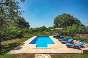 a swimming pool with lounge chairs and an umbrella at Villa Altura in Valtura