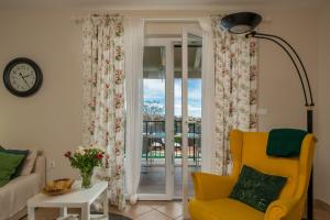 a living room with a yellow chair and a sliding glass door at Villa Laura in Krnica