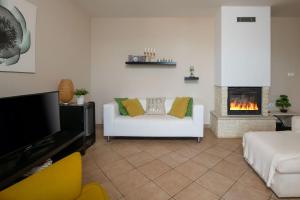 a living room with a white couch and a fireplace at Villa Laura in Krnica