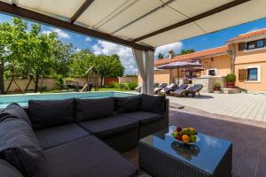 a patio with a couch and a table with a bowl of fruit at Villa Zvane in Žminj