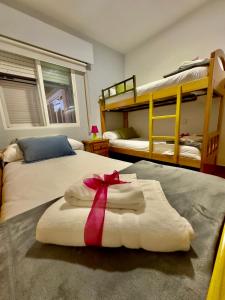 a bedroom with two bunk beds and a towel with a ribbon at El Charrancito in El Espinar