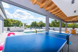 eine Tischtennisplatte im Hinterhof mit Pool in der Unterkunft Villa mit Privatpool, Ping-Pong, BBQ in Štokovci
