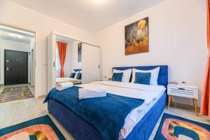 a bedroom with a large bed with a blue blanket at Grandis Residence Apartment in Braşov