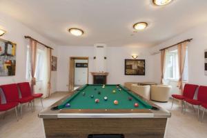 a living room with a pool table and red chairs at Villa Rustica in Fondole