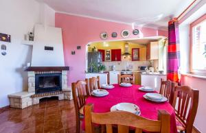 a dining room with a table and a fireplace at Villa Ninetta in Galižana