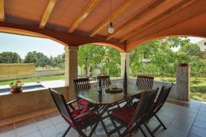 a patio with a table and chairs on a porch at Villa Maria Betiga in Peroj