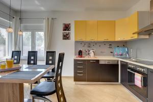 a kitchen with yellow cabinets and a table with chairs at Villa Marcelia in Pula
