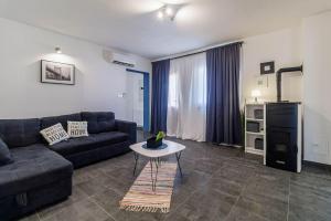 a living room with a couch and a table at Holiday House Ulika in Loborika