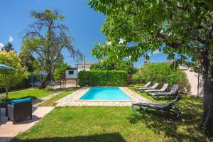 una piscina in un cortile con sedie a sdraio di Villa Sherpa a Sveti Lovreč Pazenatički