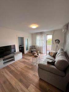 a living room with a couch and a flat screen tv at Apartman Trsat in Rijeka