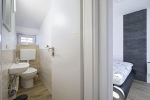 małą łazienkę z toaletą i umywalką w obiekcie Haus Bernarda w Medulinie +22 zdjęcia