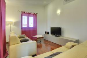 ein Wohnzimmer mit 2 Sofas und einem Flachbild-TV in der Unterkunft Villa Erica in Pula