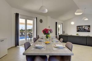 a dining room with a long table with flowers on it at Villa mit Pool und klimatisierten Schlafzimmern in Vodnjan