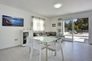 a living room with a table and a couch at 500 Meter zum Strand mit Privatpool, Meerblick, Klima, WLAN in Ližnjan