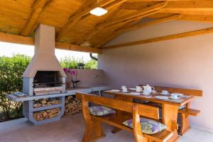 un patio con mesa y horno de leña en Villa mit privatem Pool, WLAN, Klima und Bäder en suite, en Pula