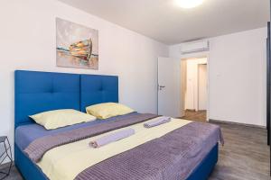 duże łóżko w pokoju z niebieskim zagłówkiem w obiekcie Luxuriöse Villa mit privatem Pool und Sonnenterrasse w mieście Valbandon +24 zdjęcia