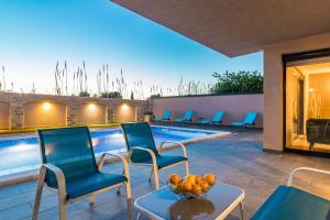 patio z krzesłami i basenem w obiekcie Luxuriöse Villa mit privatem Pool und Sonnenterrasse w mieście Valbandon
