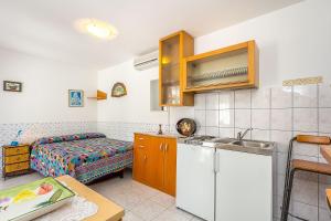 una cocina con fregadero y una cama en una habitación en Ferienwohnung in bester Lage, nahe dem Meer, en Barbariga