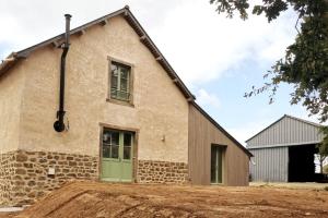 ein altes Steingebäude mit grüner Tür in der Unterkunft Grange moderne près de Rennes avec jolie vue ! in Gévezé