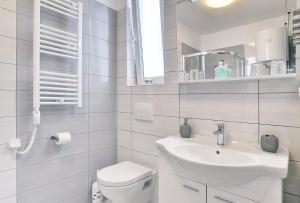 a white bathroom with a toilet and a sink at Appartement Tiffany in Ližnjan +11 photos