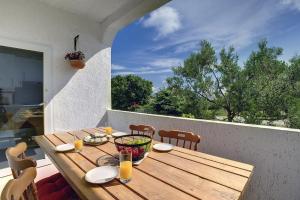a wooden table on a balcony with a table and chairs at Appartement Tiffany in Ližnjan