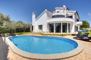 ein Haus mit einem Pool vor einem Haus in der Unterkunft Villa Mutila in Medulin