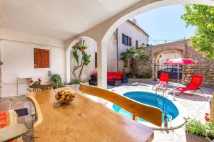 メドゥリンにあるFerienwohnung nur 700 Meter bis zum Sandstrand mit Pool, Küche, Bad, Balkon, BBQのテーブルとプールのあるパティオ