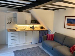 a living room with a couch and a kitchen at Bryntirion Farmhouse Apartment with Hot Tub in Llanfair Caereinion