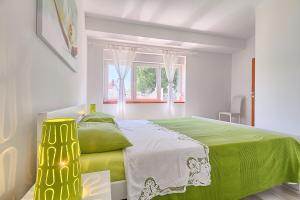 a bedroom with a green bed and a window at Im Jahr 2014 renoviertes Ferienhaus 400 Meter zum Strand in Premantura