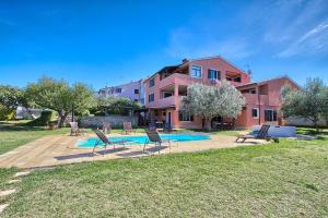 a house with a pool and chairs in a yard at Traumhaft nur 400 Meter zum Strand in Banjole