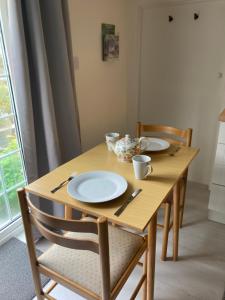 uma mesa de madeira com pratos e utensílios em Bryntirion Farmhouse Apartment with Hot Tub em Llanfair Caereinion