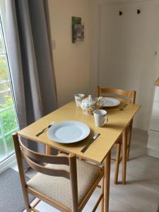 una mesa de madera con platos y utensilios. en Bryntirion Farmhouse Apartment with Hot Tub en Llanfair Caereinion