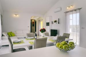 een keuken en een woonkamer met een tafel en stoelen bij Appartement mit großem Garten und Grillbereich in Valtura