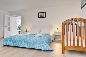 a bedroom with a bed and a wooden crib at Appartement mit großem Garten und Grillbereich in Valtura