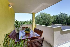 een patio met een tafel en stoelen op een balkon bij Appartement mit großem Garten und Grillbereich in Valtura