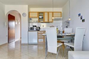 - une cuisine avec des appareils blancs, une table et des chaises dans l'établissement Helle Ferienwohnung 400 Meter zum Strand, à Ližnjan 12 autres photos