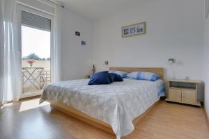 une chambre avec un lit avec des oreillers bleus dessus dans l'établissement Helle Ferienwohnung 400 Meter zum Strand, à Ližnjan