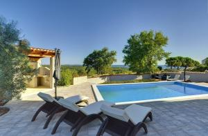 a swimming pool with two chairs and a swimming pool at Traumhafte Villa mit privatem Pool, Sauna, Meerblick in Peroj