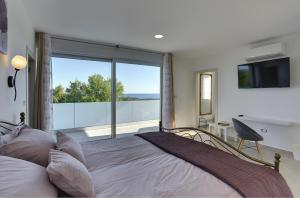 a bedroom with a bed and a large window at Traumhafte Villa mit privatem Pool, Sauna, Meerblick in Peroj +18 photos
