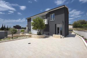 a house with a large driveway in front of it at Villa mit privatem Pool, eigener Crossfit-Halle, Billard in Premantura