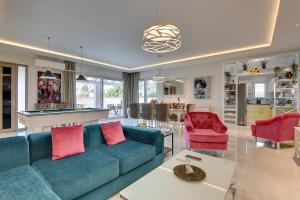 a living room with a blue couch and red chairs at Villa mit privatem Pool, eigener Crossfit-Halle, Billard in Premantura
