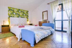 a bedroom with a bed and two blue chairs at Einzigartige Villa nur 1 km bis zum Strand mit privatem Pool, BBQ, Klima, WLAN in Ližnjan +22 photos